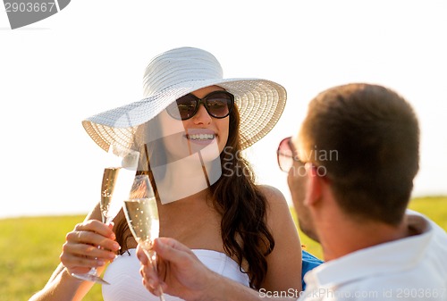 Image of smiling couple drinking champagne on picnic