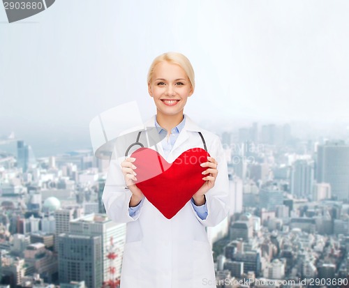 Image of smiling female doctor with heart and stethoscope