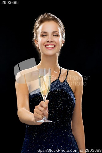 Image of smiling woman holding glass of sparkling wine