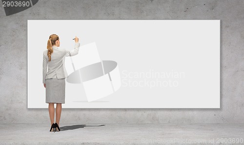 Image of businesswoman writing with marker on white board