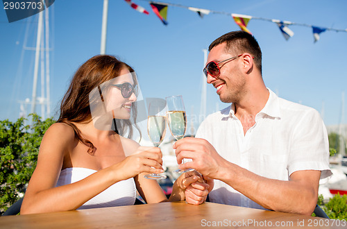 Image of smiling couple drinking champagne at cafe