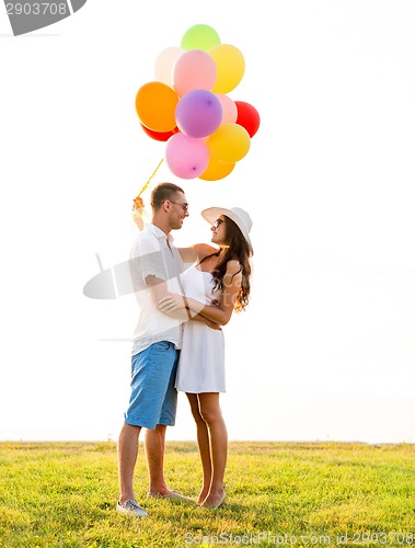 Image of smiling couple with air balloons outdoors