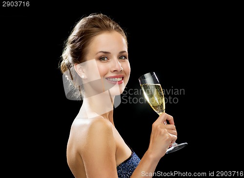 Image of smiling woman holding glass of sparkling wine