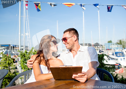 Image of smiling couple with menu at cafe