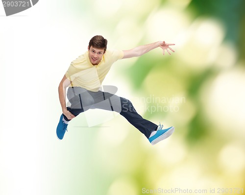 Image of smiling young man jumping in air