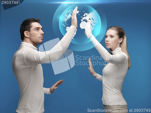 Image of man and woman working with globe hologram