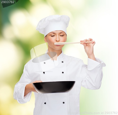 Image of smiling female chef with pan and spoon