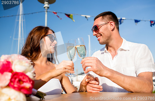 Image of smiling couple drinking champagne at cafe