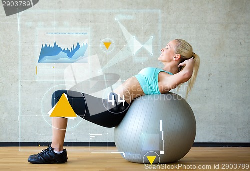 Image of smiling woman with exercise ball in gym
