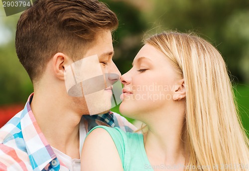 Image of smiling couple touching noses in park