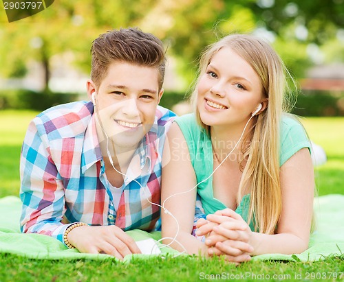 Image of smiling couple with smartphone and earphones