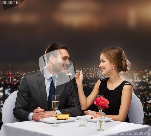 Image of smiling couple eating dessert at restaurant