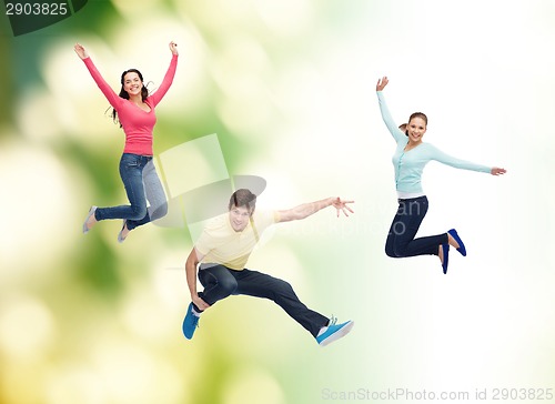 Image of group of smiling teenagers jumping in air