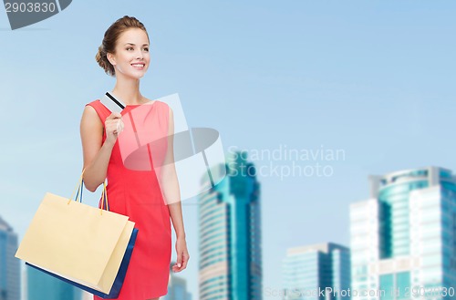 Image of smiling woman with shopping bags and plastic card