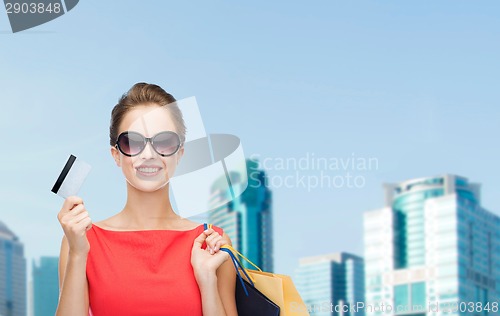 Image of smiling woman with shopping bags and plastic card