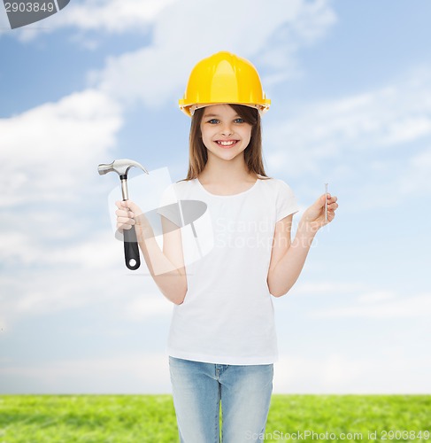 Image of smiling little girl in hardhat with hammer