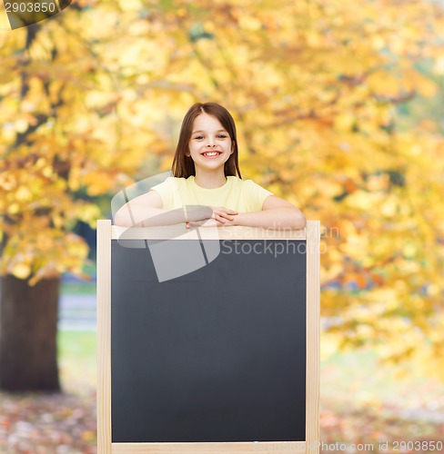 Image of happy little girl with blank blackboard