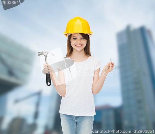 Image of smiling little girl in hardhat with hammer