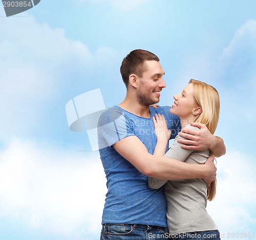 Image of smiling couple hugging and looking at each other