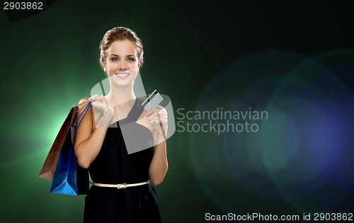 Image of smiling woman with shopping bags and credit card