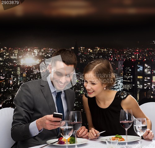 Image of smiling couple eating main course at restaurant