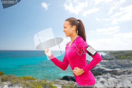 Image of smiling young woman running outdoors
