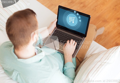 Image of close up of man working with laptop at home