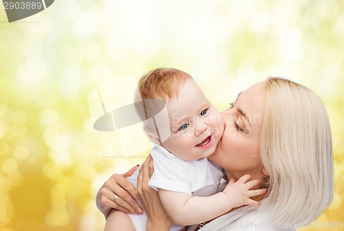 Image of happy mother kissing smiling baby