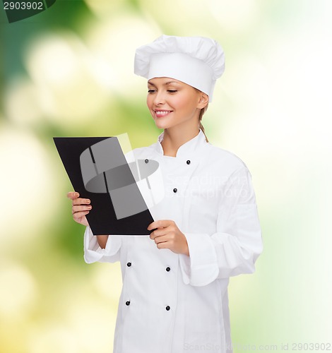 Image of smiling female chef with black blank paper