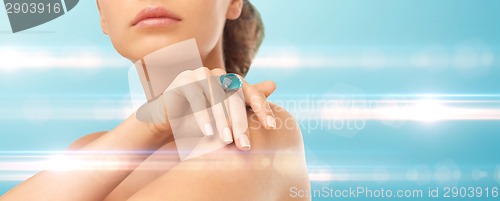 Image of closeup of woman hand with big blue cocktail ring