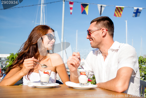 Image of smiling couple eating dessert at cafe