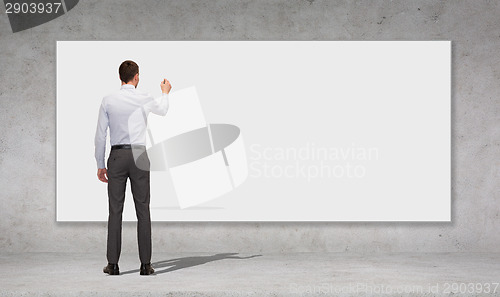 Image of businessman writing with marker on white board