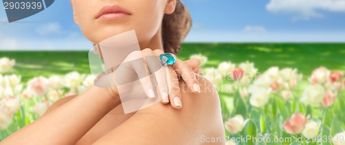 Image of closeup of woman hand with big blue cocktail ring