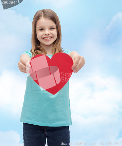 Image of smiling little girl giving red heart