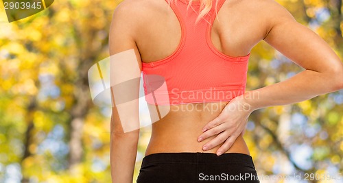 Image of close up of sporty woman touching her back