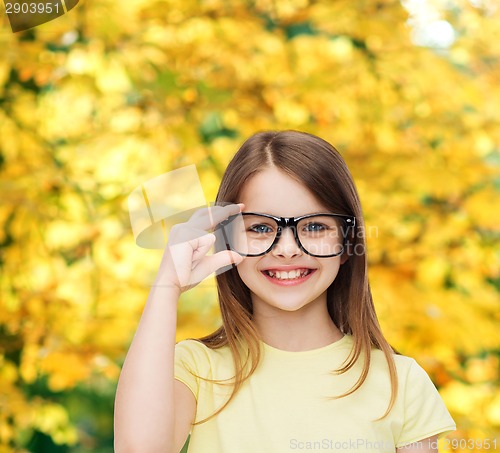 Image of smiling cute little girl in black eyeglasses