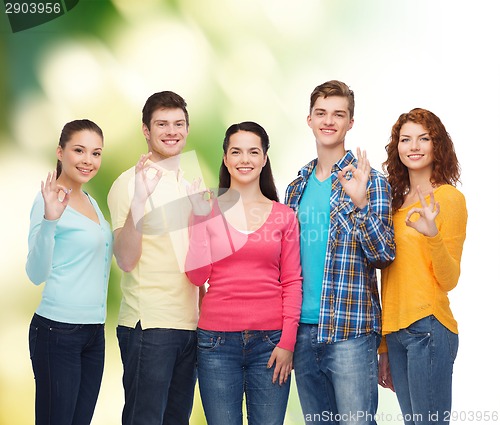 Image of group of smiling teenagers over green background