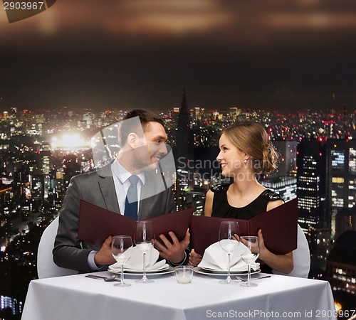 Image of smiling couple with menus at restaurant