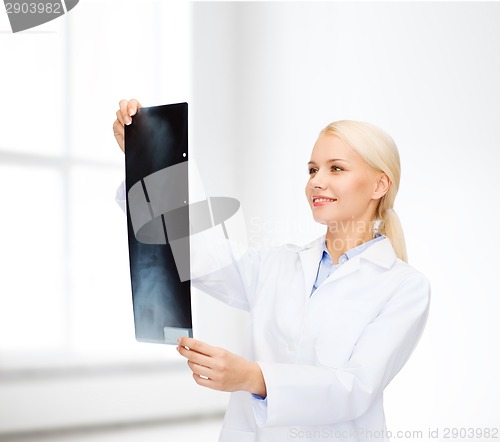 Image of smiling female doctor looking at x-ray