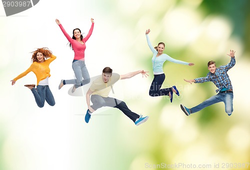 Image of group of smiling teenagers jumping in air