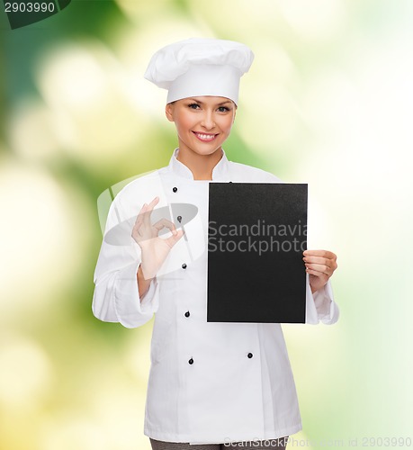 Image of smiling female chef with black blank paper