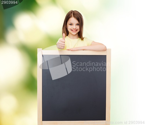 Image of happy little girl with blank blackboard