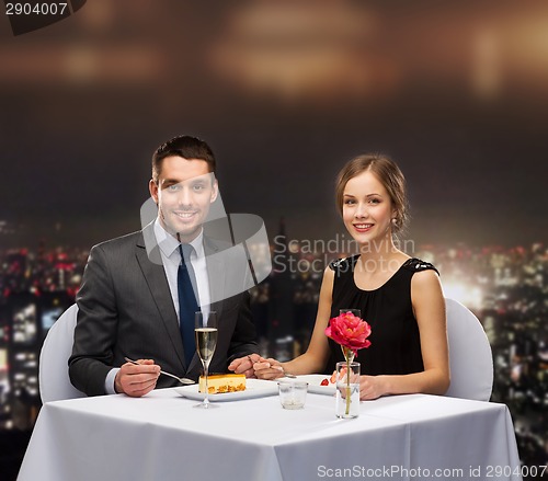 Image of smiling couple eating dessert at restaurant