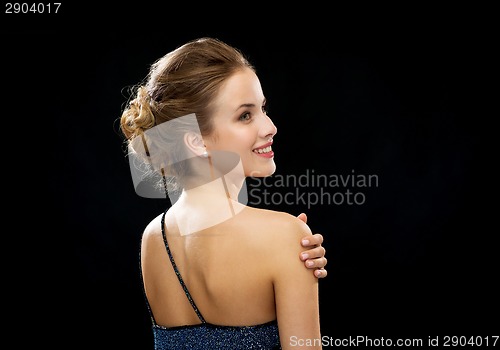 Image of smiling woman in evening dress from the back