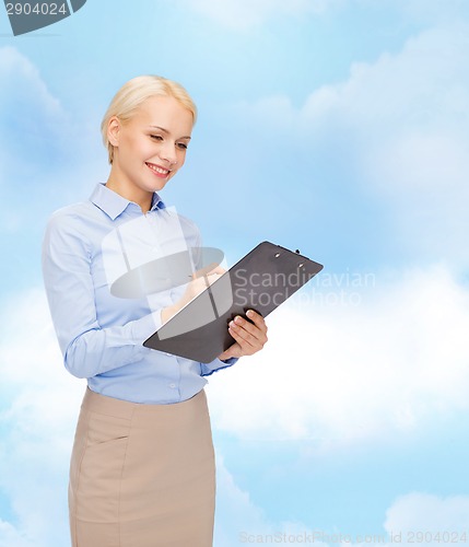 Image of smiling businesswoman with clipboard and pen