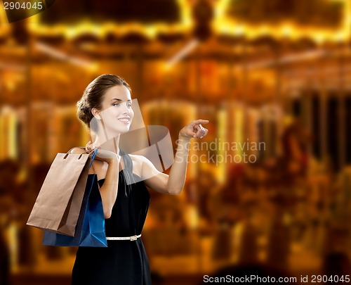 Image of smiling woman in dress with shopping bags