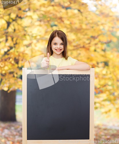 Image of happy little girl with blank blackboard