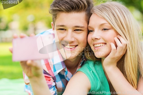 Image of smiling couple making selfie in park