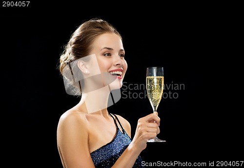 Image of laughing woman holding glass of sparkling wine