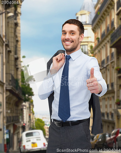 Image of smiling young businessman showing thumbs up